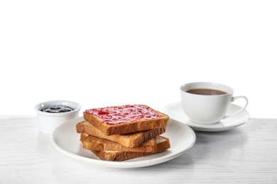 Photo of Toasts with jam and cup of tea on white wooden table