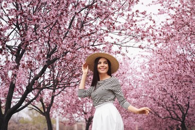 Photo of Pretty young woman in park with blooming trees. Spring look