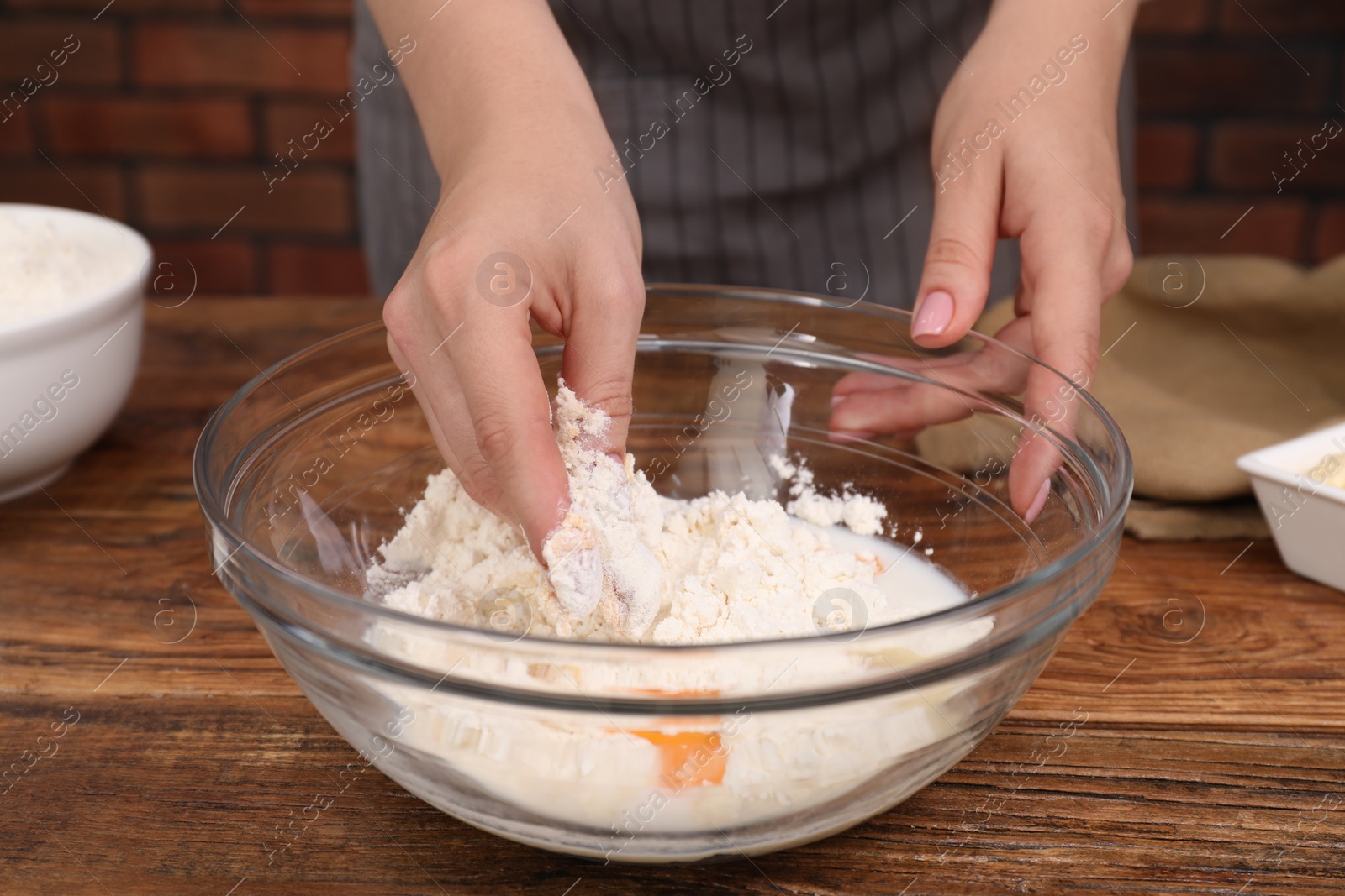 Photo of Preparing tasty baklava. Woman making dough at wooden table, closeup