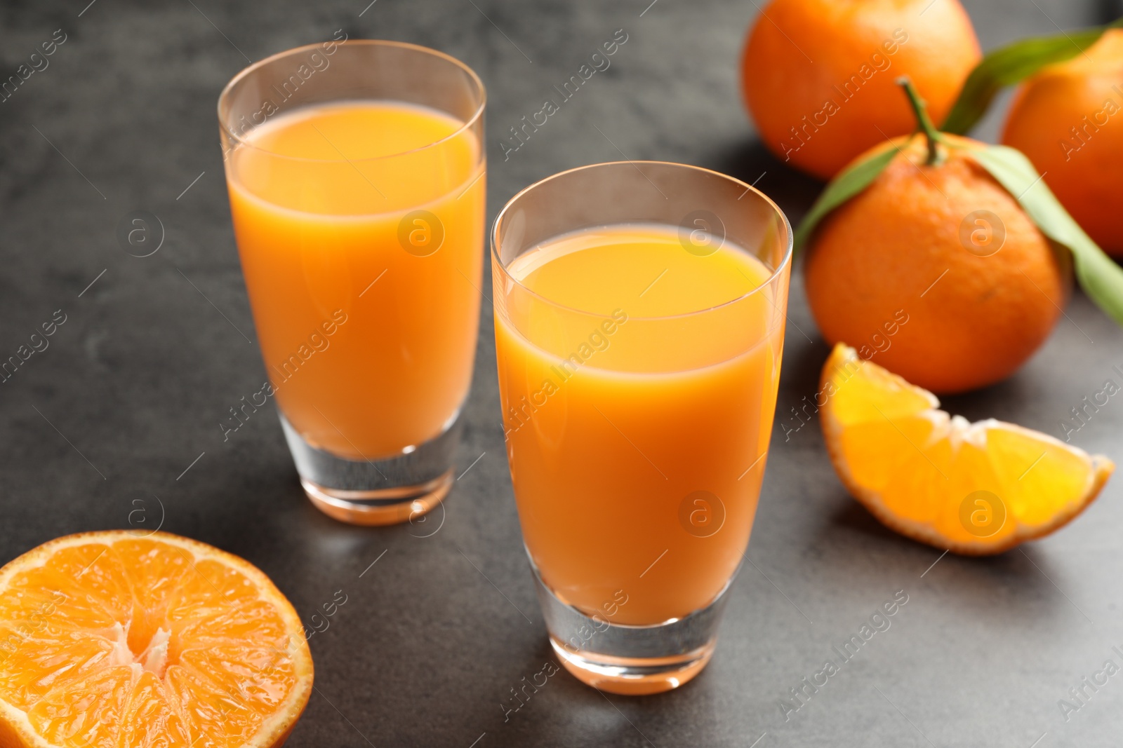 Photo of Delicious tangerine liqueur and fresh fruits on grey table, closeup
