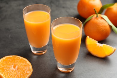 Delicious tangerine liqueur and fresh fruits on grey table, closeup