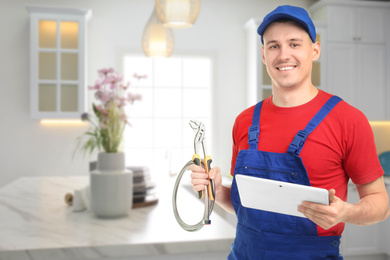 Image of Young plumber with tablet in kitchen, space for text