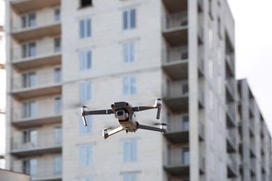 Photo of Modern drone flying at building site. Aerial survey