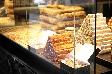 Photo of Showcase with different fresh Turkish desserts, closeup