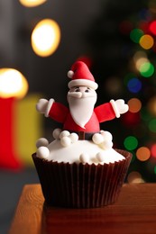 Photo of Beautifully decorated Christmas cupcake on wooden table indoors