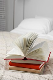 Books on white soft blanket in bedroom