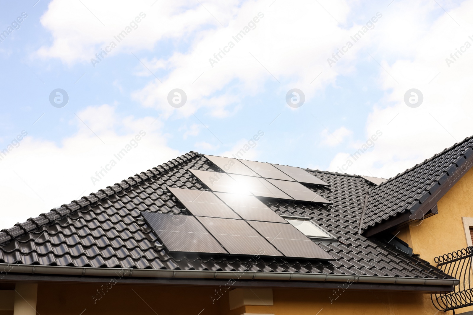 Photo of House with installed solar panels on roof. Alternative energy