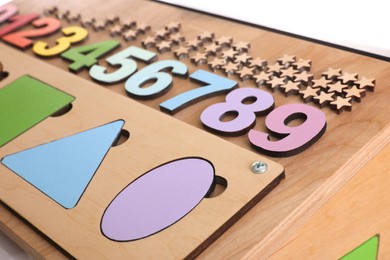 Photo of Closeup view of busy board on white background. Baby sensory toy