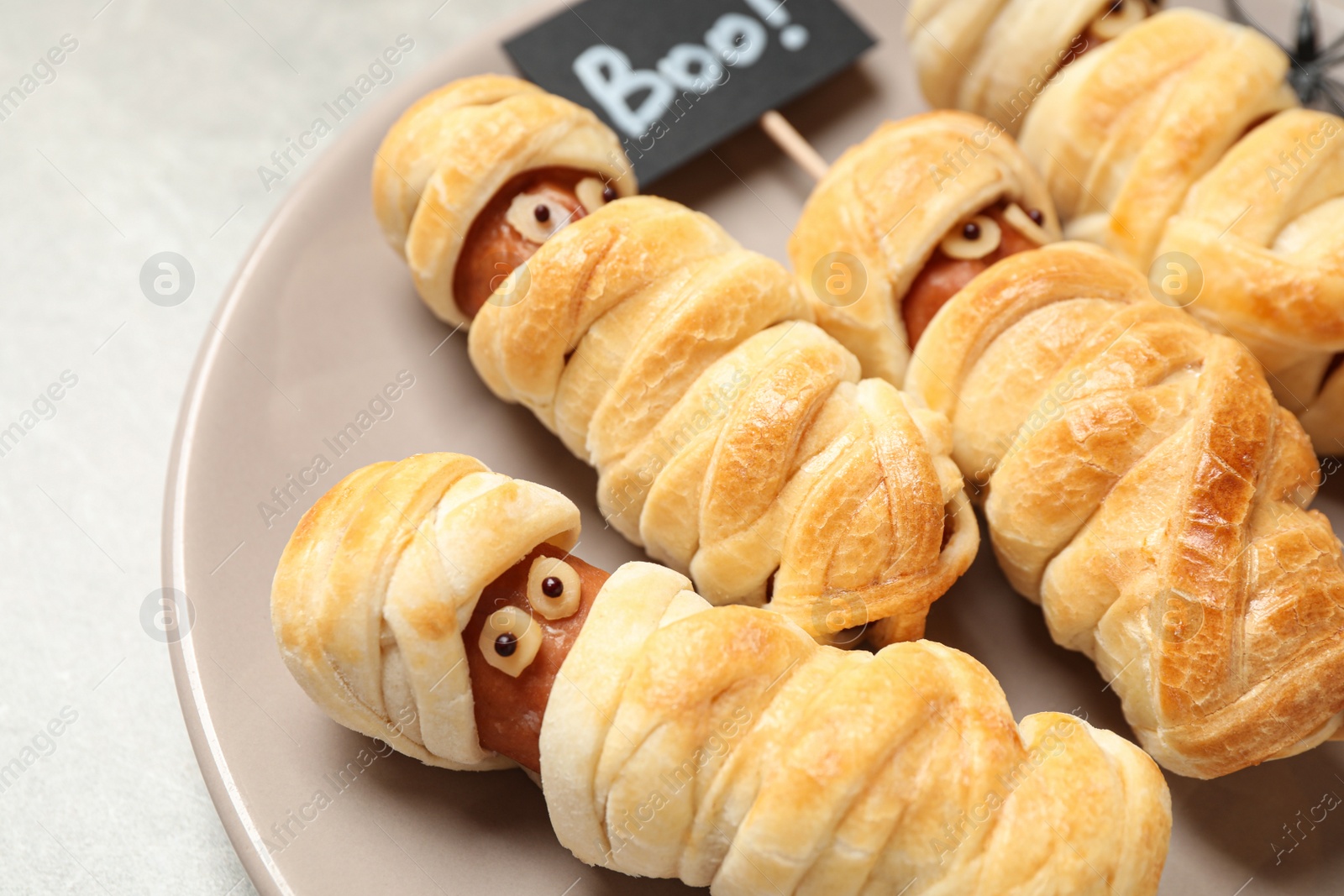 Photo of Spooky sausage mummies on table, closeup. Halloween treat