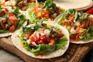 Photo of Delicious tacos with vegetables and meat on table, closeup