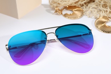 New stylish elegant sunglasses with color lenses on light background