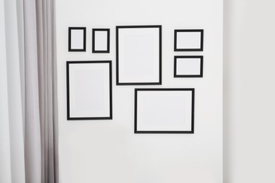 Photo of Empty frames hanging on white wall indoors