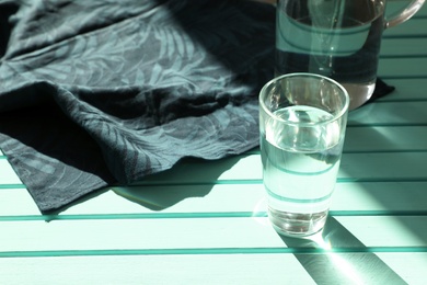 Photo of Glass of fresh water on color table. Space for text