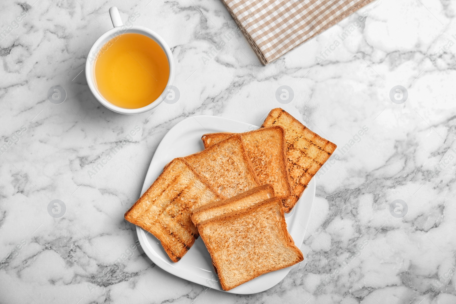 Photo of Plate with toasted bread and cup of tea on light background, top view