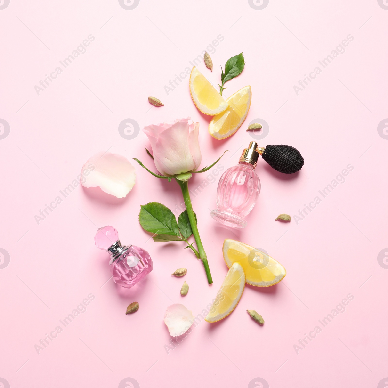 Photo of Flat lay composition with elegant perfumes on pink background