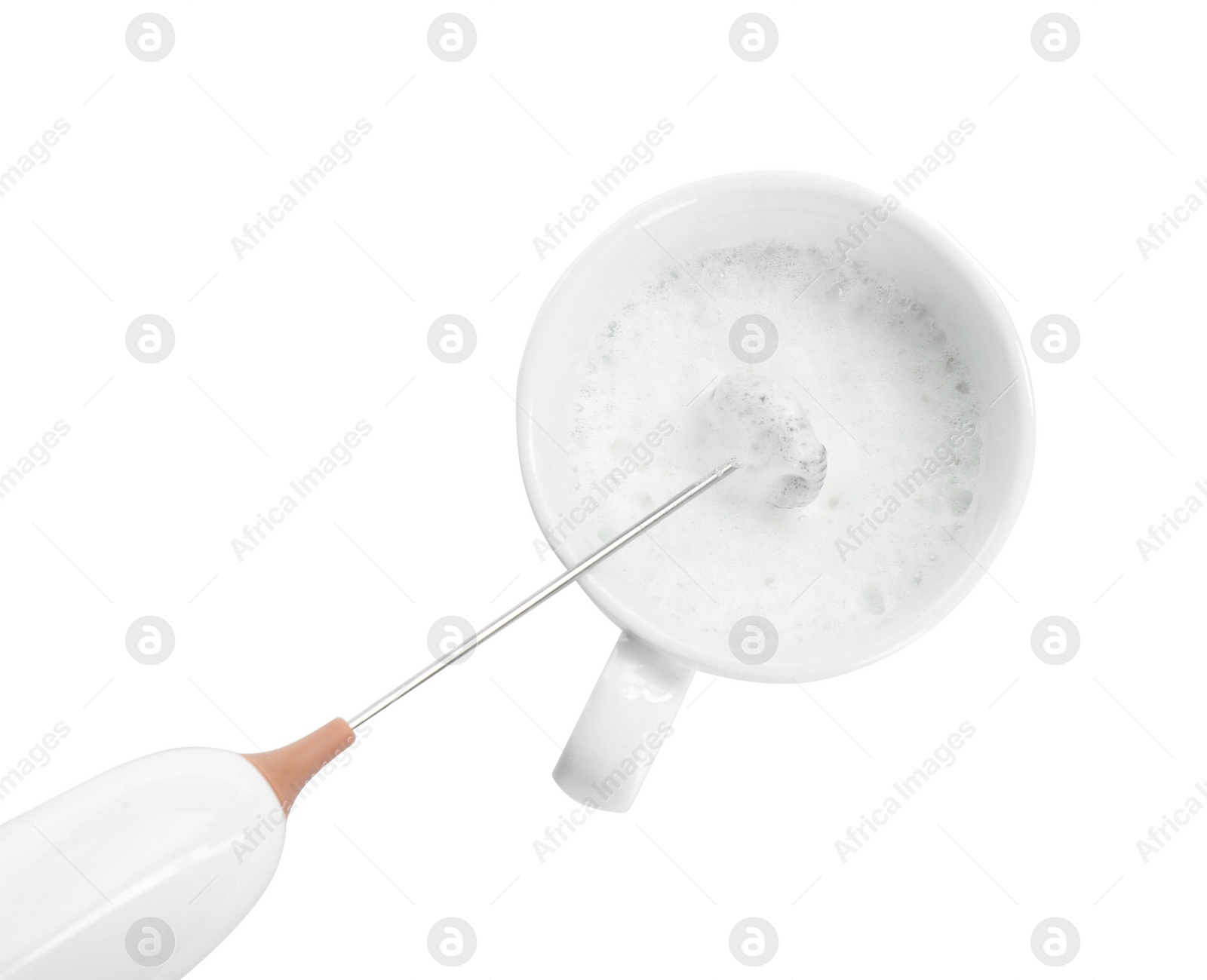 Photo of Whisking milk in cup with mini mixer (frother wand) isolated on white, top view