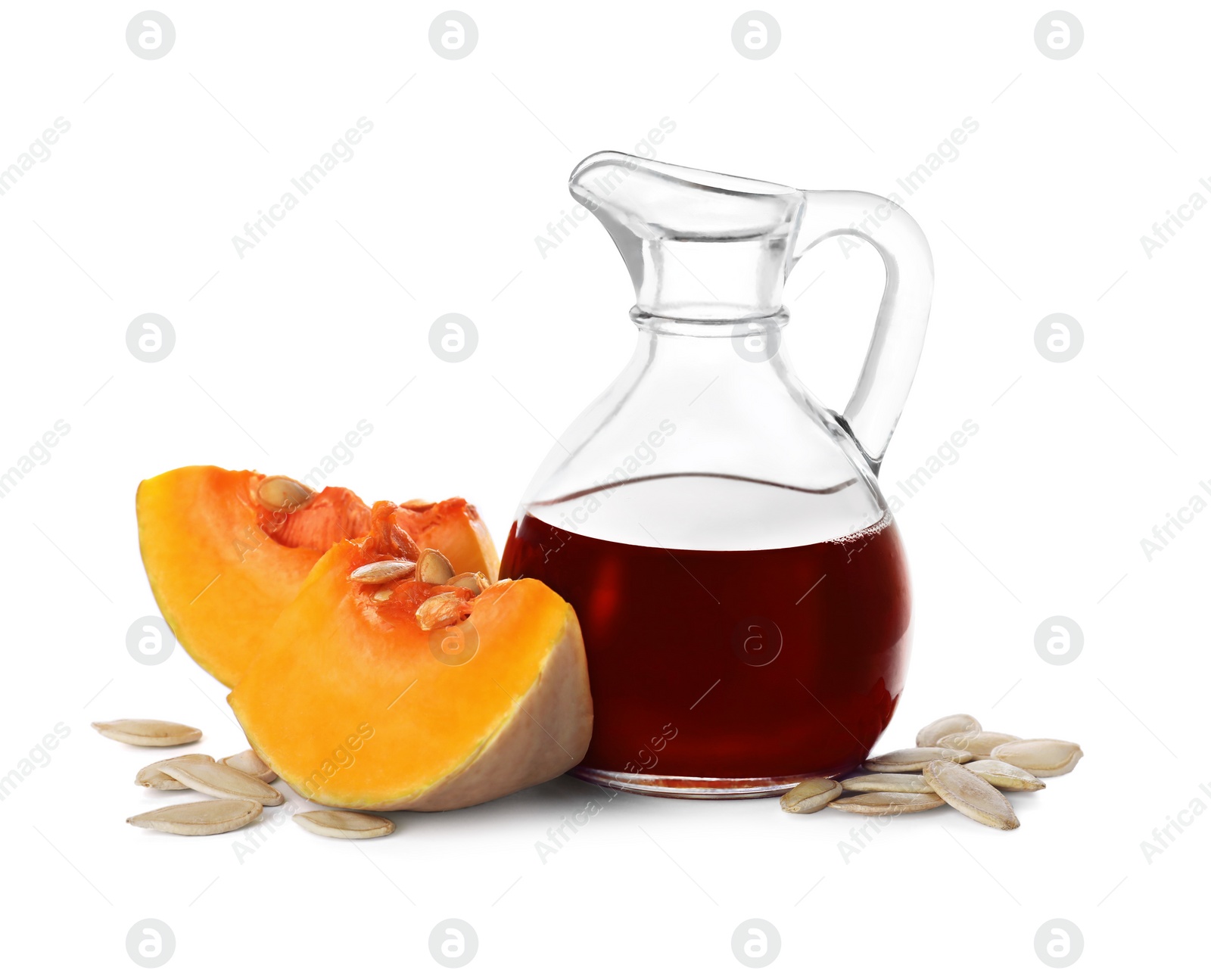 Photo of Fresh pumpkin seed oil in glass jug isolated on white