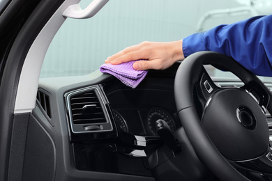 Photo of Car wash worker cleaning automobile interior, closeup