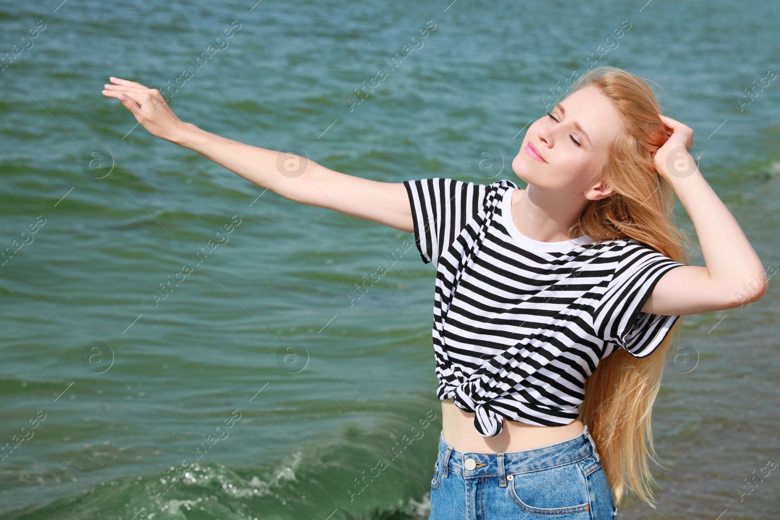 Photo of Beautiful young woman near sea on sunny day in summer