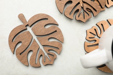 Leaf shaped wooden cup coasters on white table, flat lay