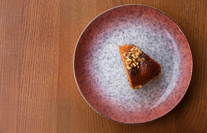 Photo of Plate with slice of carrot cake on wooden table, top view