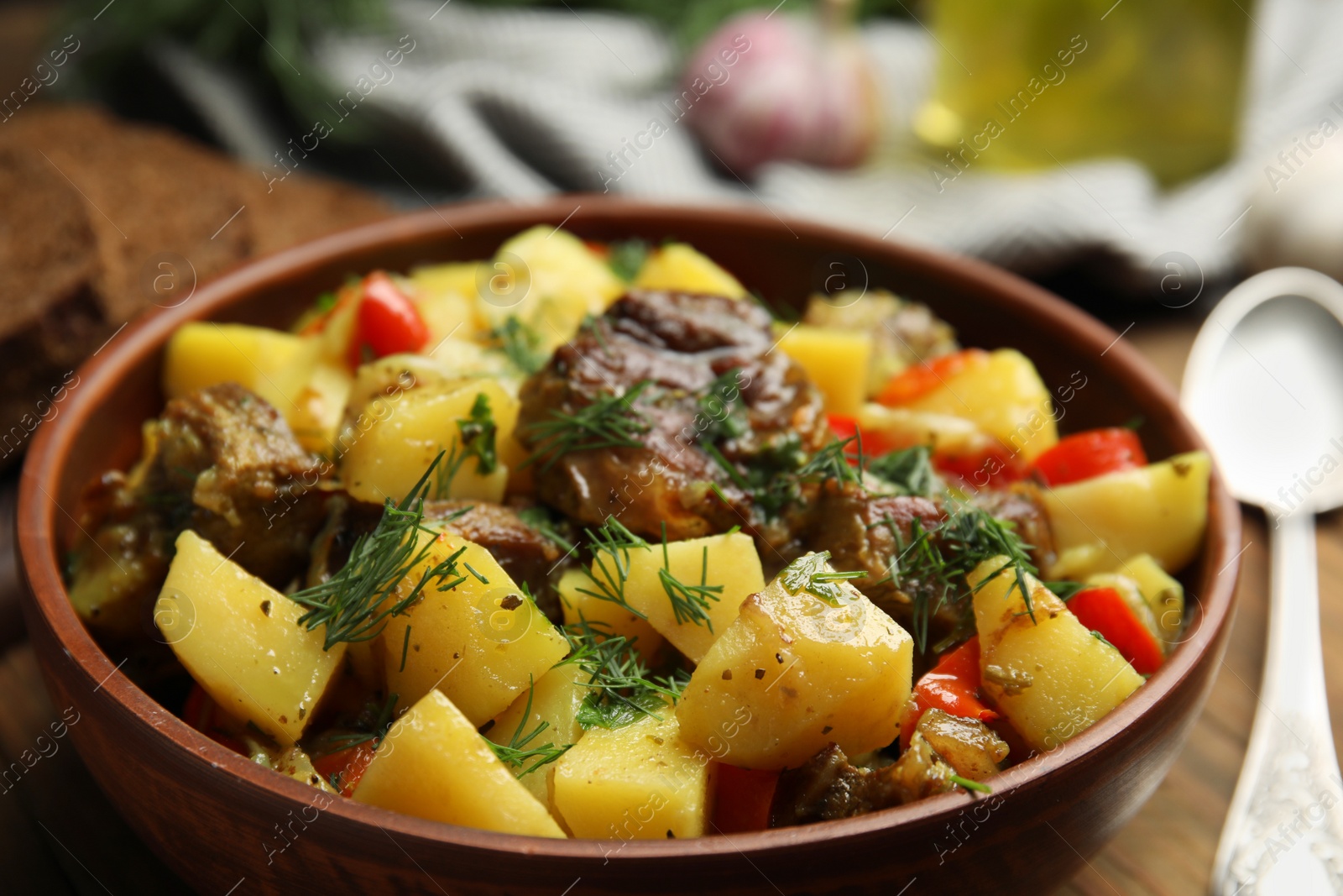 Photo of Tasty cooked dish with potatoes in earthenware, closeup