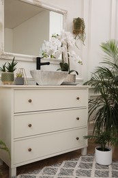 Stylish bathroom interior with modern furniture and beautiful houseplants