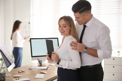 Photo of Man flirting with his colleague in office. Space for text