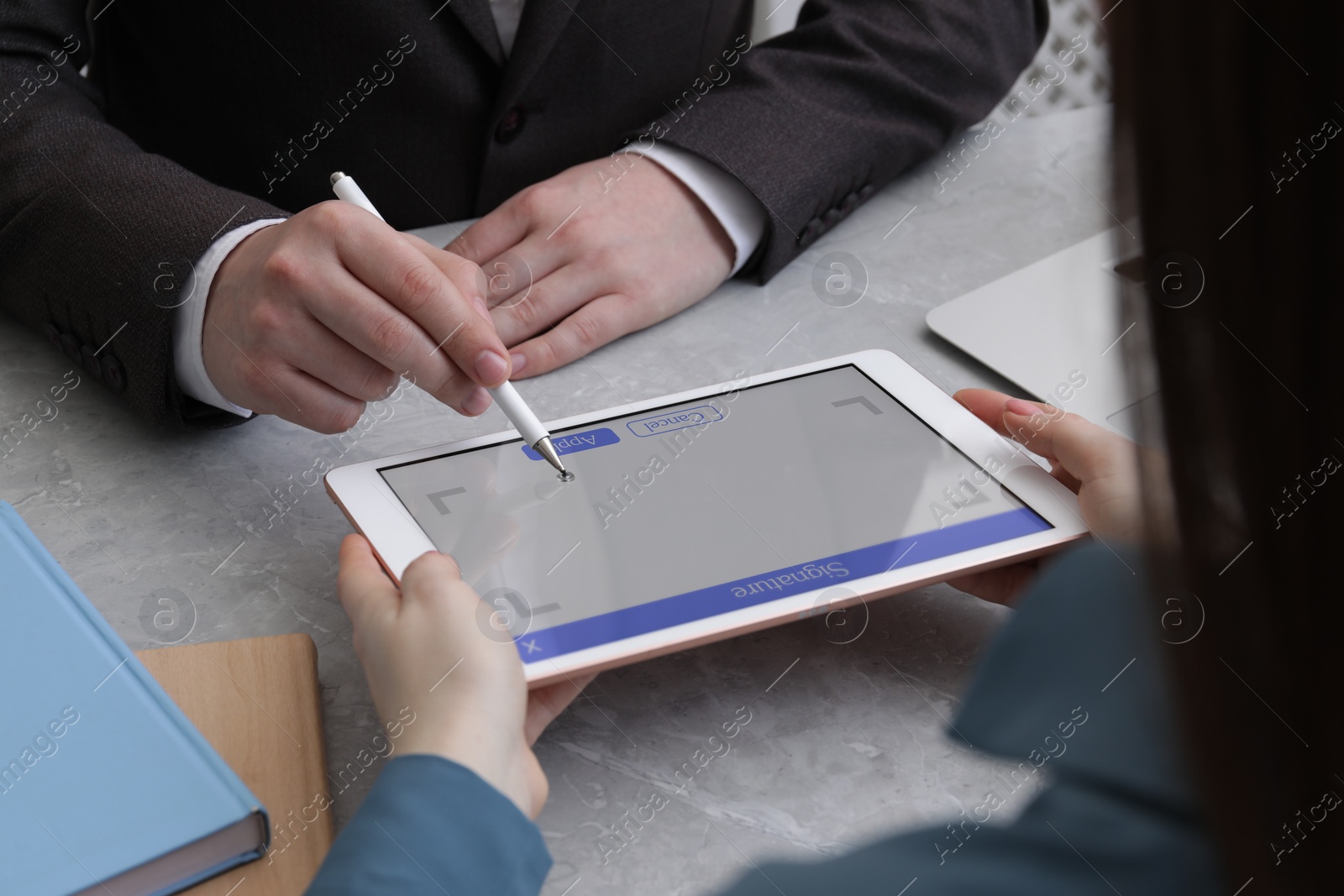 Image of Electronic signature. Man using stylus and tablet at table, closeup