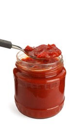 Photo of Spoon of delicious lecho over glass jar on white background