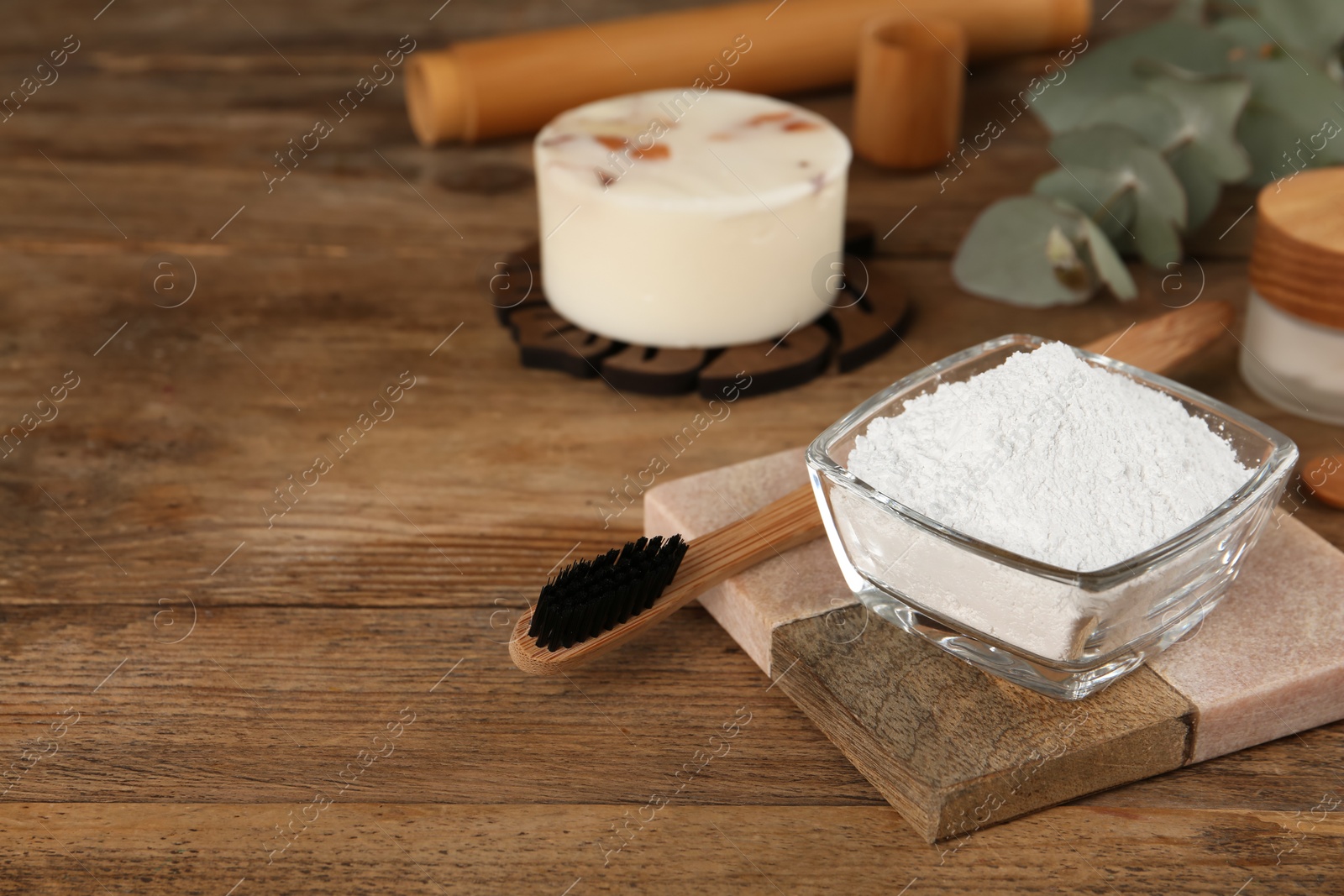 Photo of Tooth powder and brush on wooden table, space for text