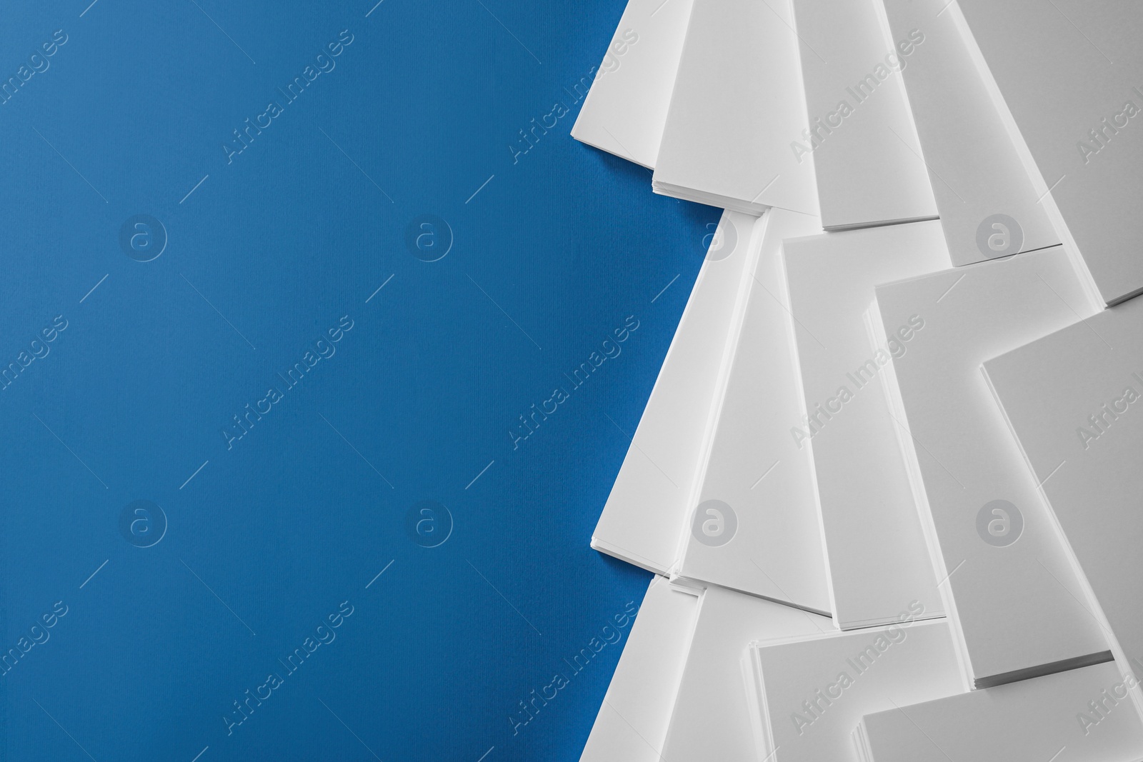 Photo of Many stacks of paper sheets on blue background, flat lay. Space for text