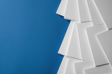 Photo of Many stacks of paper sheets on blue background, flat lay. Space for text