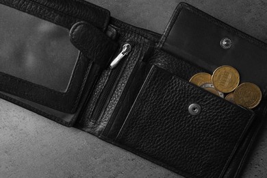 Poverty. Black wallet and coins on grey table, top view