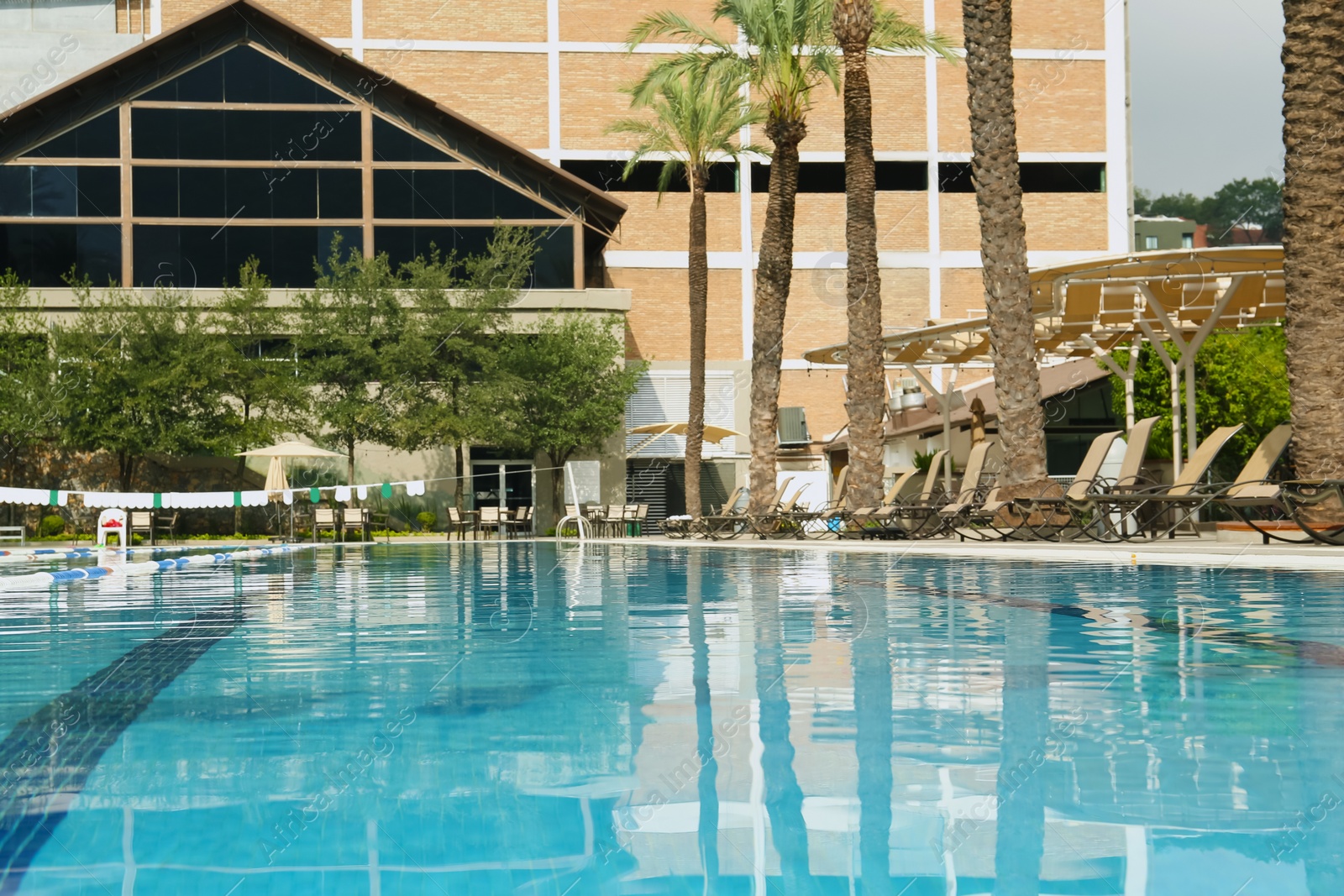 Photo of Swimming pool and sunbeds at luxury resort