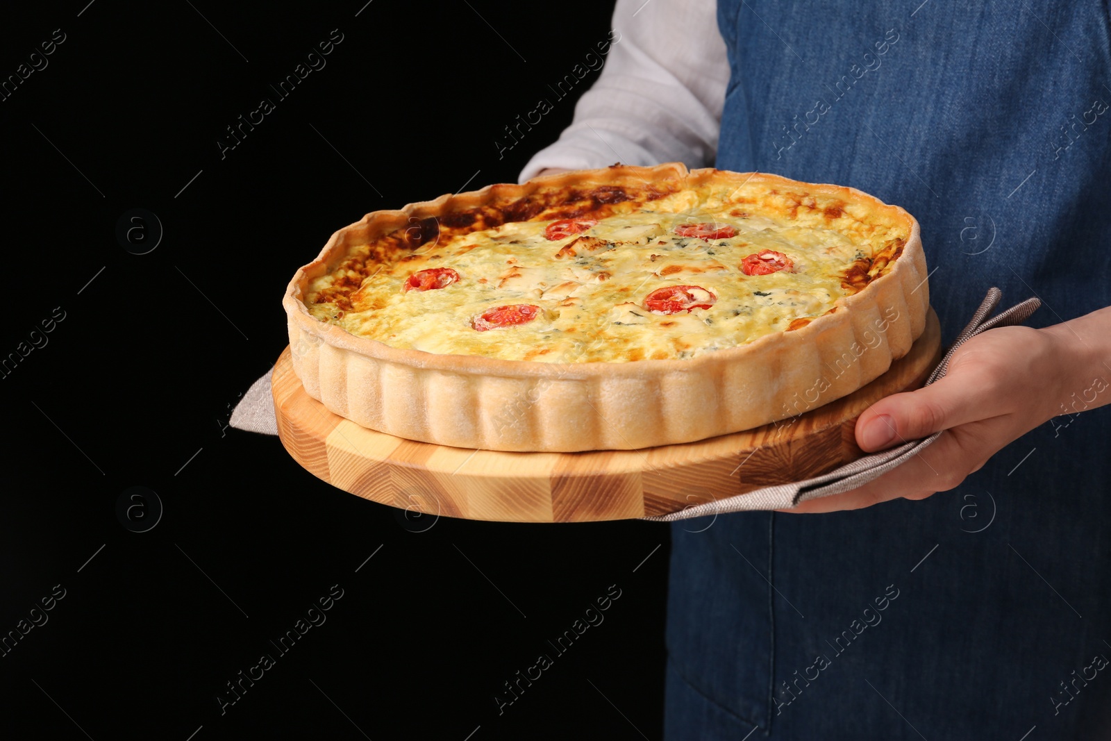 Photo of Woman with delicious homemade cheese quiche on black background, closeup