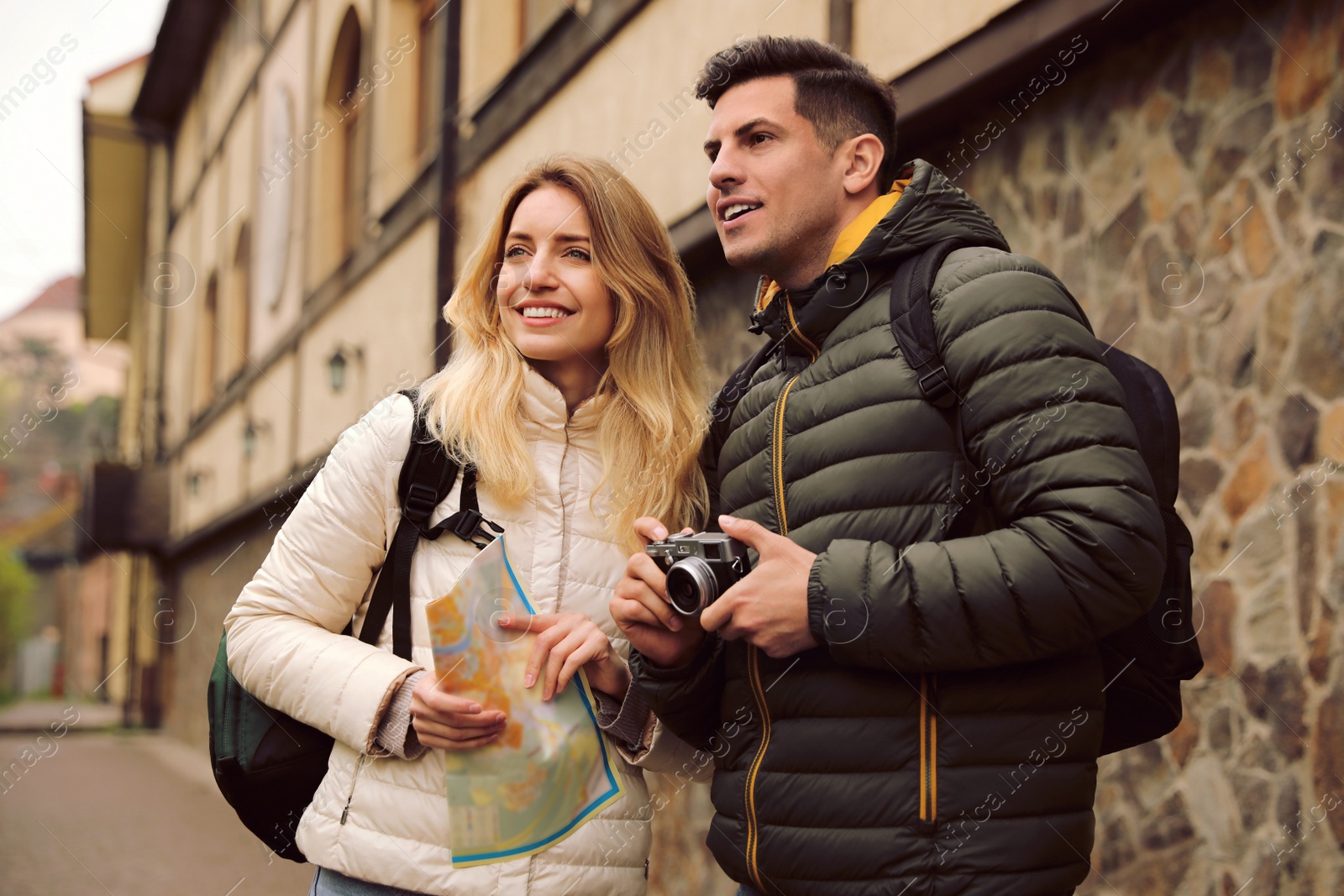 Photo of Couple of tourists with map and camera on city street