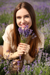 Photo of Young woman with lavender bouquet in field on summer day