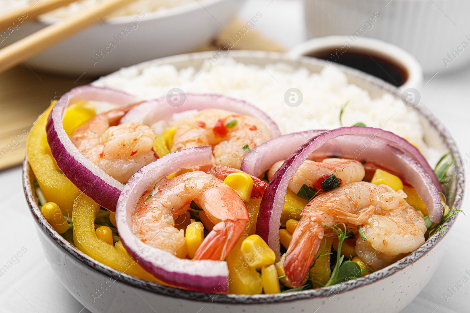 Photo of Delicious poke bowl with shrimps, rice and vegetables on white table, closeup