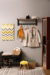 Photo of Hallway interior with stylish furniture, clothes and accessories