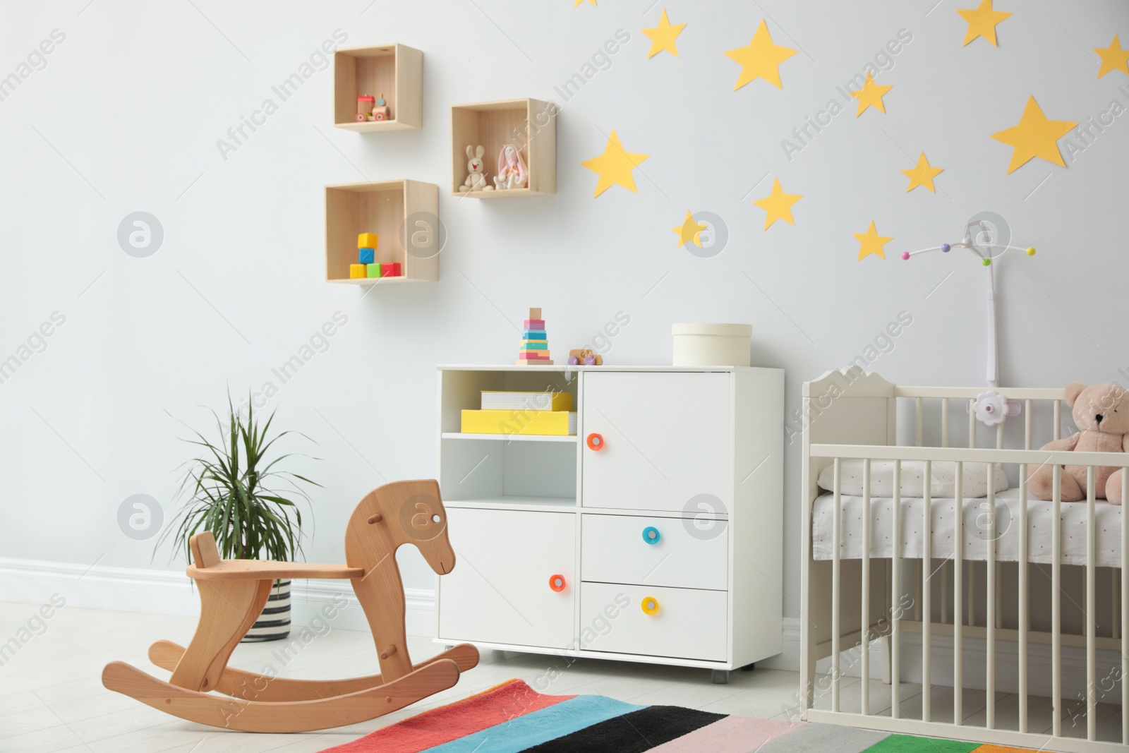 Photo of Stylish baby room interior with crib and toys