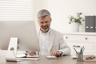 Professional accountant working at wooden desk in office