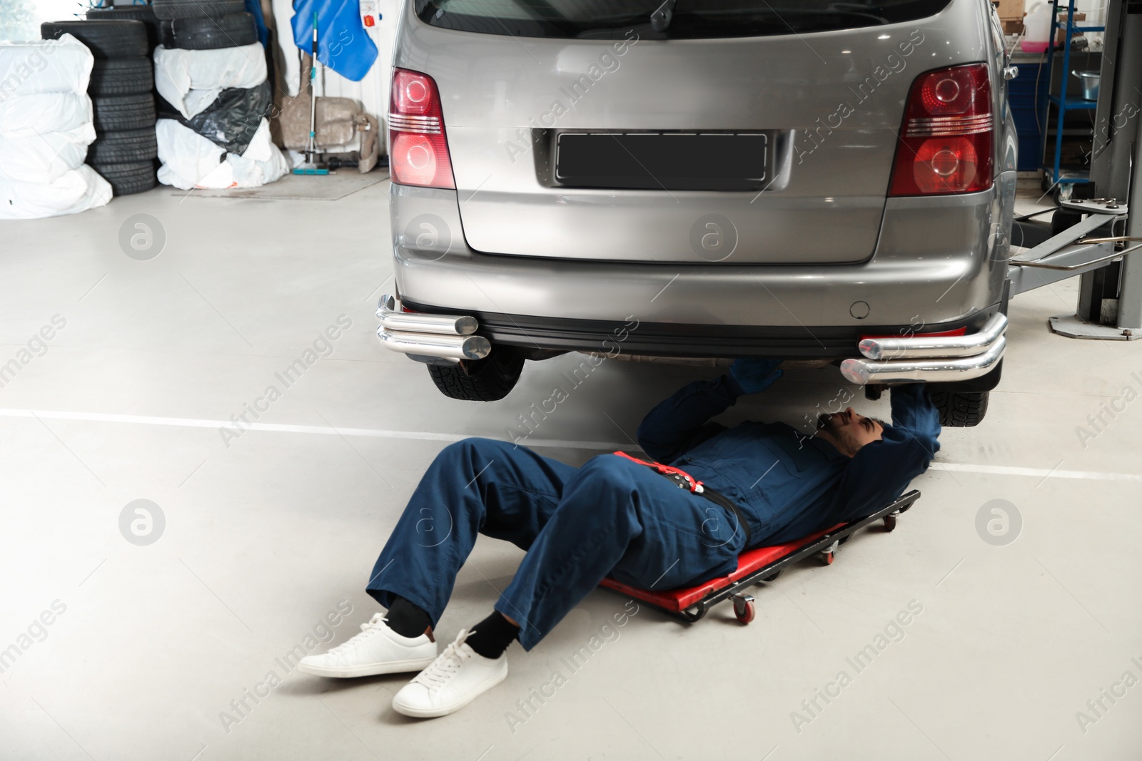 Photo of Technician checking modern car at automobile repair shop