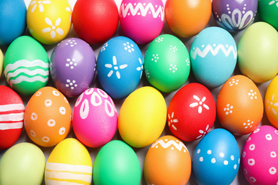 Colorful Easter eggs with different patterns as background, top view