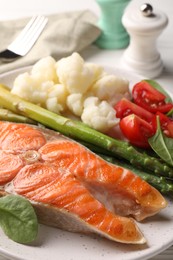 Photo of Healthy meal. Grilled salmon steak and vegetables served on white table, closeup