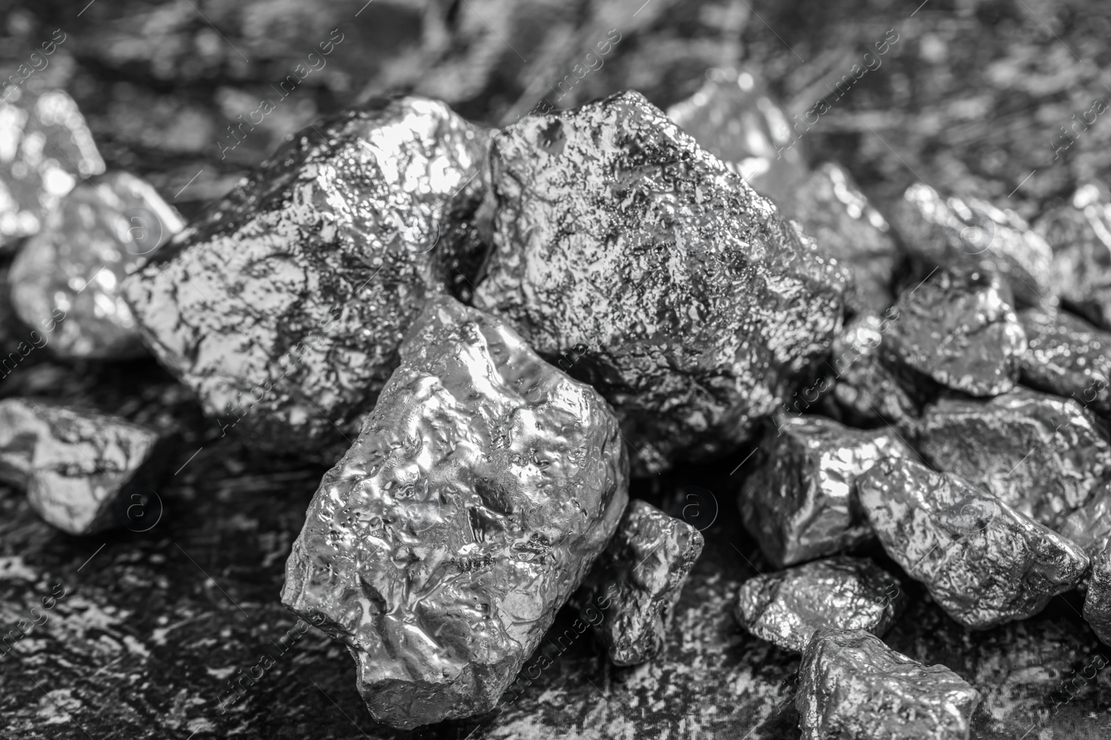 Photo of Pile of silver nuggets on grey textured table, closeup