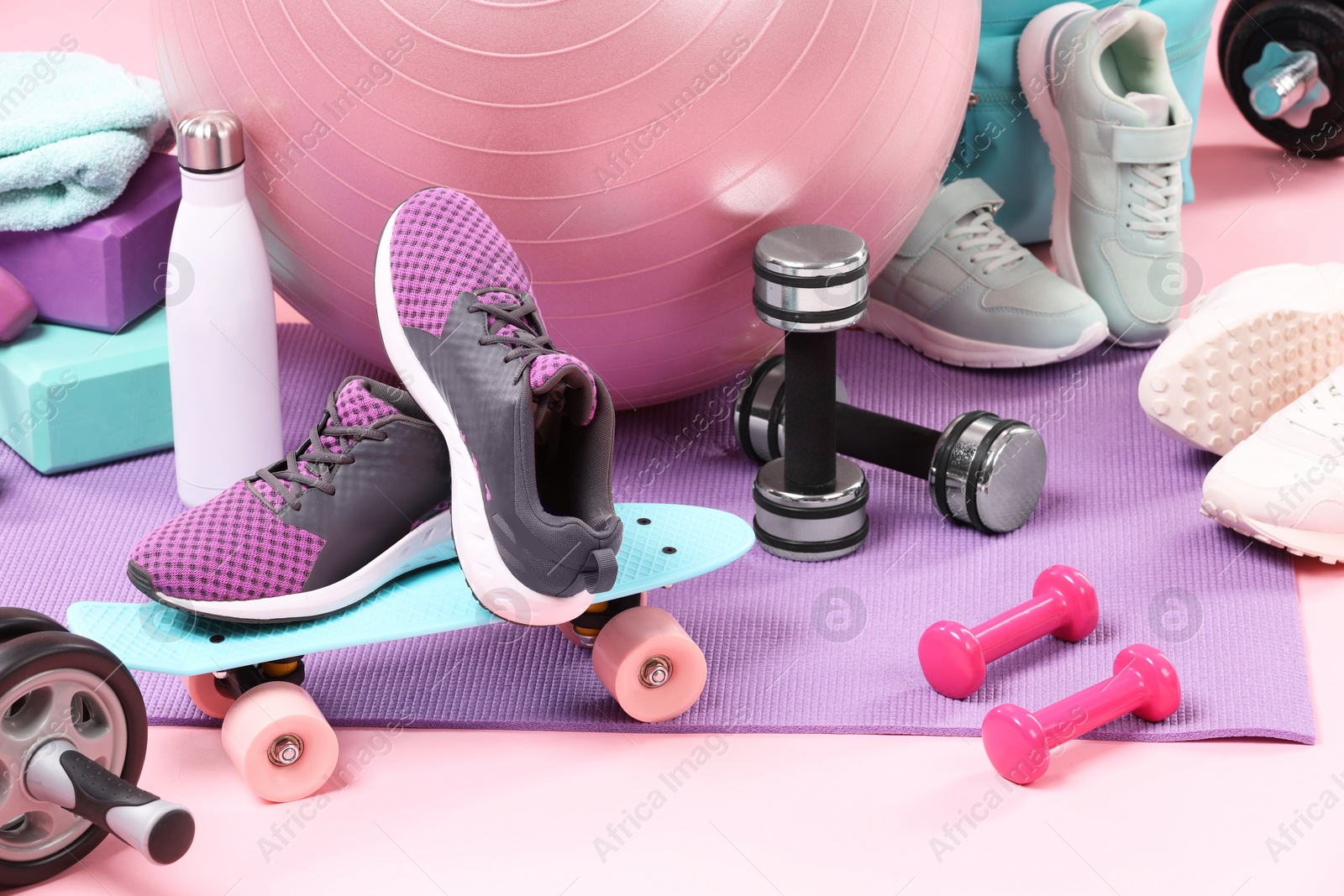 Photo of Many different sports equipment on pink background