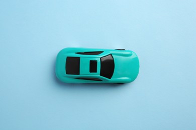 Photo of One bright car on light blue background, top view. Children`s toy