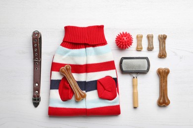 Flat lay composition with clothes, food and accessories for dog on white wooden table