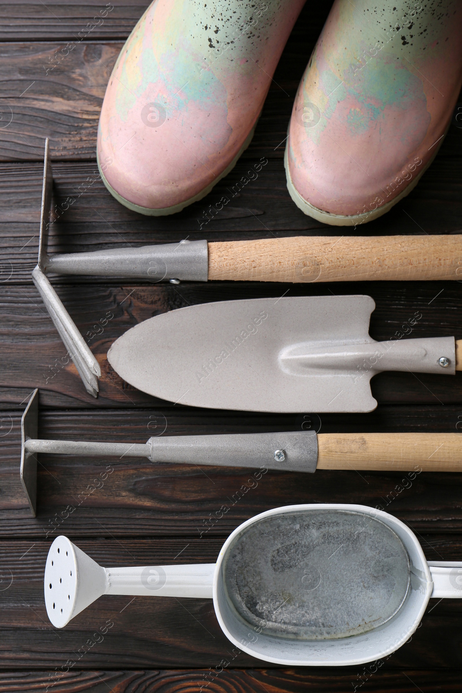 Photo of Flat lay composition with watering can and gardening tools on wooden table